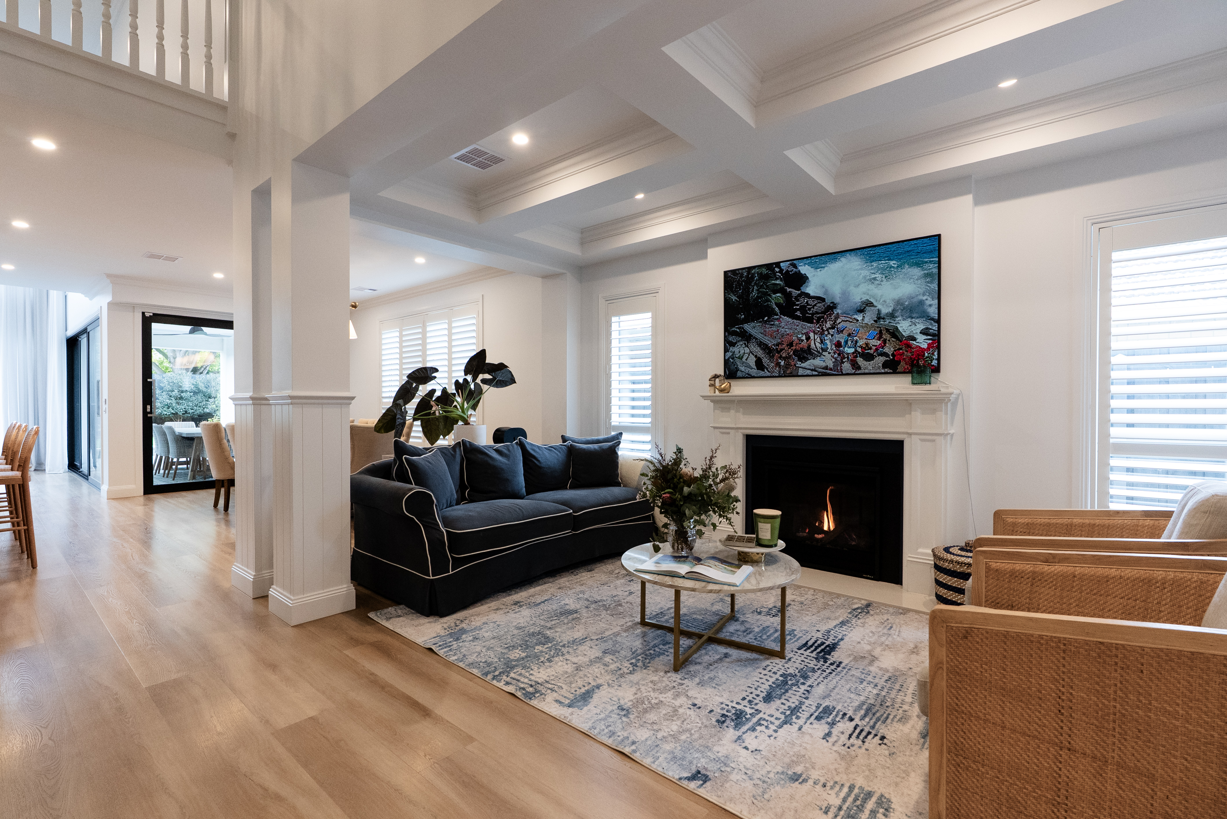 Living room with coffered ceiling, navy sofa and fireplace